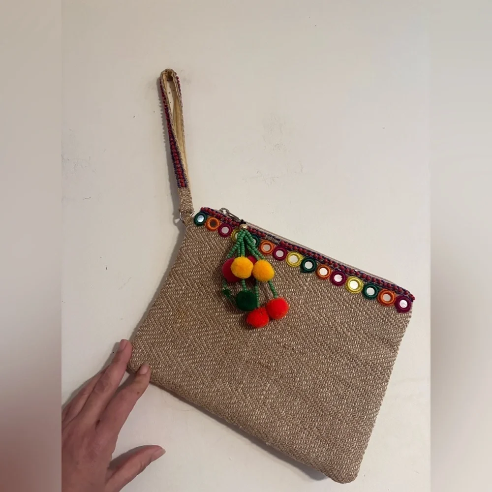 bohemian-style woven clutch jute with pom pom accents